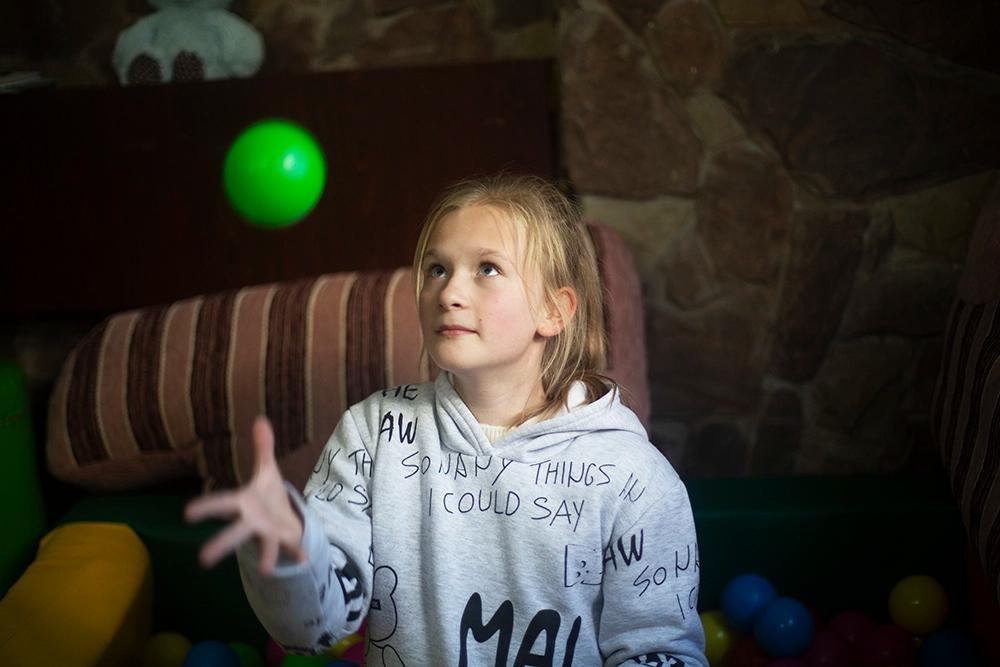 Flicka som jonglerar med en grön boll